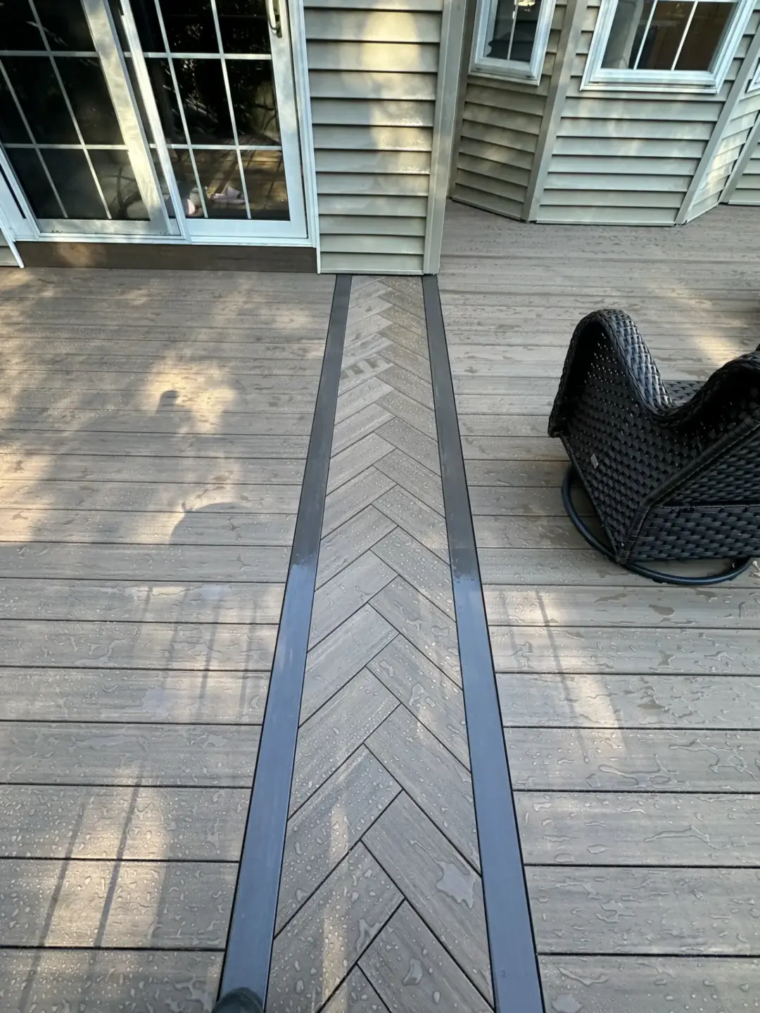 Composite decking with chevron inlay transition leading to sliding glass door