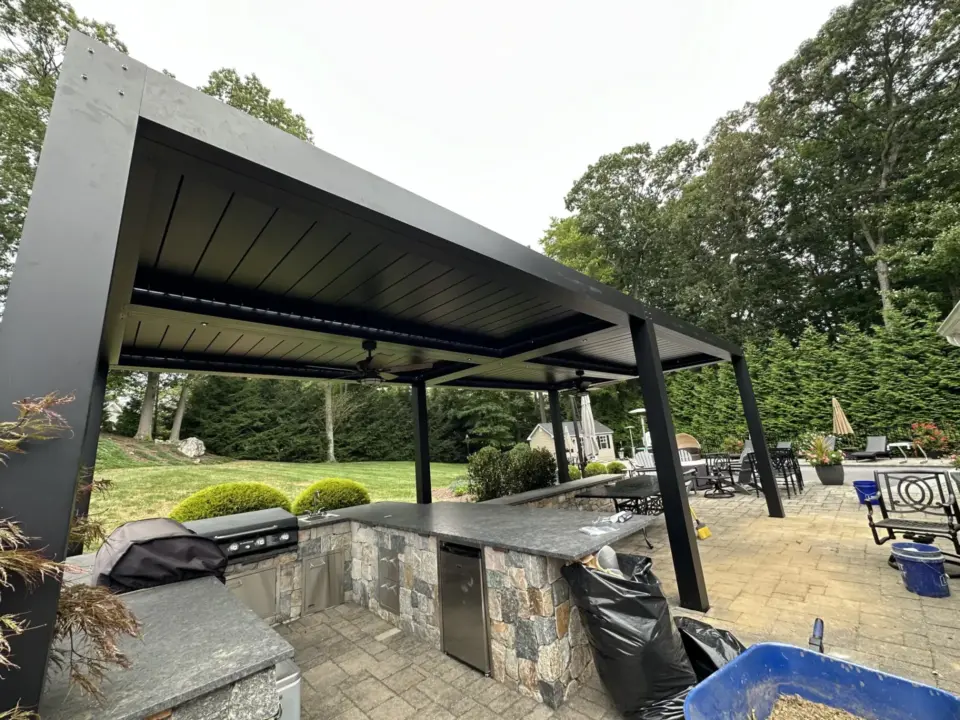 Modern black pergola with outdoor kitchen grill and stone countertops